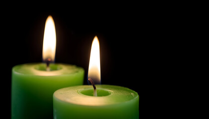Two Green Candles With Soft Flames Illuminating a Dark Background in a Calm Atmosphere