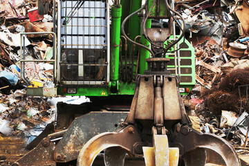 Hydraulic manipulator on a heap of scrap metal.