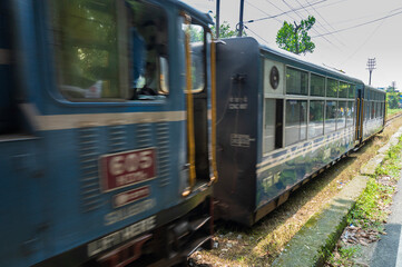 Darjeeling,West Bengal,India - 10th August 2023 : Diesel Toy train passing through Himalayan roads. Darjeeling Himalayan Railway, narrow gauge railway between New Jalpaiguri and Darjeeling.
