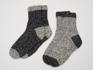 two pair of knitted wool socks in two shades of grey