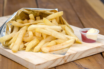 Golden French Fries Served with Ketchup and Mayonnaise on a Restaurant Table
