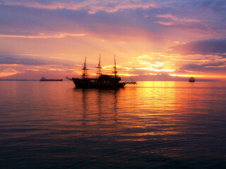 Sunset over the sea with a pirate ship-bar. 