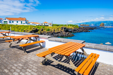 Benches on ocean coast in Madalena village, Pico island, Azores, Portugal