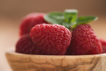 fresh raspberries in wood bowl on table