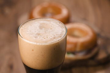 glass of stout beer agains bagels with ham