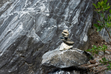 Grey and black rock in a marble quarry. In the foreground is a pyramid of rough broken stones. Background.