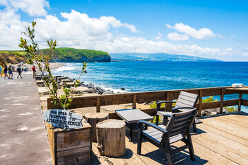 SANTA BARBARA BEACH, SAO MIGUEL ISLAND - JUN 23, 2024: Chairs with table on terrace in coastal bar at Saota Barbara beach, Sao Miguel island, Azores, Portugal.