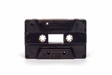 Obraz premium An image of a black audio cassette tape, showcasing its front view with exposed reel openings, representing vintage music technology from the 20th century