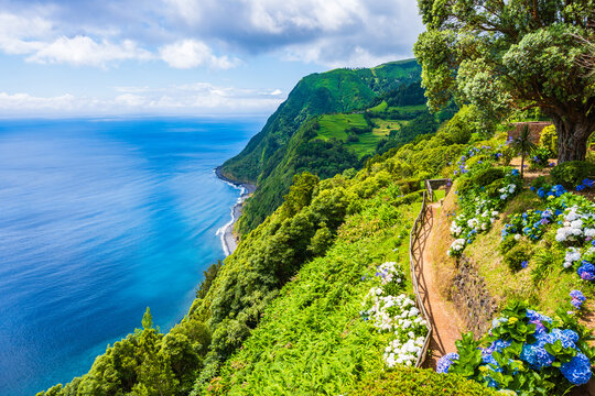 Coastal path with flowers along ocean in Ponta do Sossego tropical gardens, Sao Miguel island, Azores, Portugal