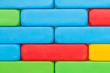 Brick wall texture. Colorful plastic toy blocks. Vibrant children construction. Creative masonry. Empty copy space kinder background. Red, blue and green bricks. Kindergarten blank blocks.