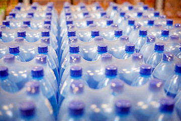 drinking water packaged in plastic containers on the shelves in the supermarket