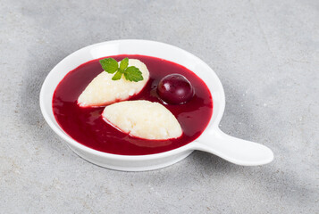Cottage cheese quenelles with cherry sauce. On a plate. Close-up