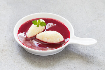 Sweet Cottage cheese quenelles with cherry sauce. On a plate. Close-up
