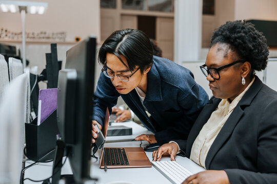 Curious male entrepreneur examining portable changer connected with laptop at desk in office