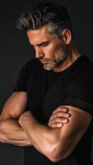 A man with a beard and gray hair is wearing a black shirt