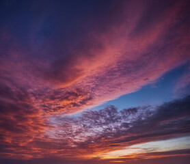 Fototapeta premium Dramatischer Sonnenuntergang mit intensiven Farben und Wolkenformationen, die den Himmel in ein faszinierendes Farbspiel aus tiefem Blau, kräftigem Rosa und leuchtendem Orange tauchen