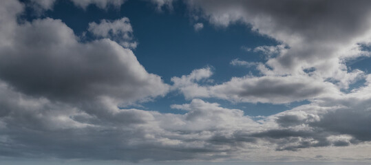Fototapeta premium Dramatische Wolkenlandschaft mit dunklen, schweren Wolken, die den Himmel bedecken und eine spannende, dynamische Stimmung erzeugen