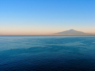 Fototapeta premium View over the bay of Naples in Italy with the volcanic mountain Vesuvius in morning haze. 