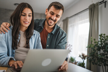 Adult woman work from home while her boyfriend hug and stand with her