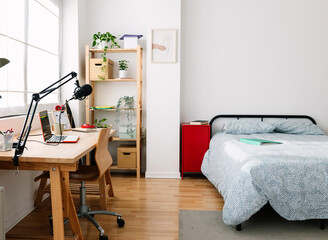Cozy mood. Interior bright teen room with bed and creative workplace desk. Young content creator teenager bedchamber.