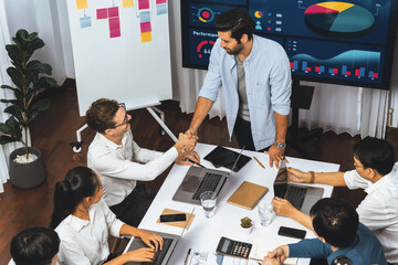 Analyst team leader shake hand with his colleague after successful data analysis meeting using FIntech software power with business intelligence or BI dashboard. Prudent