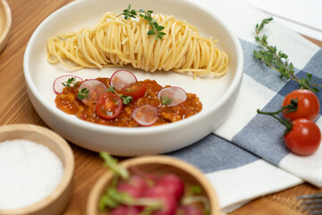 Delicious food's special menu homemade preparing station spaghetti with minced meat top tomato sauce and basil shooting placing elements serving with chef table surround decorative spices. Postulate.