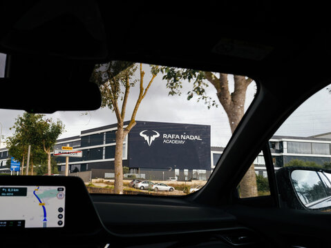 Manacor, Spain - Jul 6, 2024: The Rafa Nadal Academy in Manacor is visible from a driving car with Apple Maps CarPlay displayed on the dashboard, showcasing a renowned sports facility