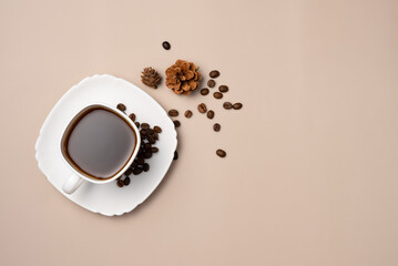 Cup of coffee, coffee beans and cones on beige background. Copy space. Flat lay, top view
