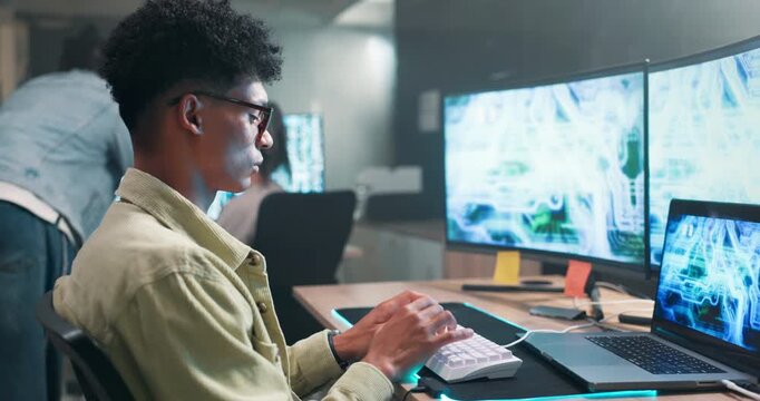 Computer screen, developer and coding on keyboard in office and productivity on futuristic technology. Man, writing and working on gaming programming on neon mousepad and connection for ai on laptop