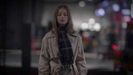 A chic woman in a trench coat exudes an elegant and mysterious vibe in the urban setting