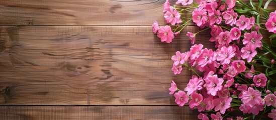 Fototapeta premium A wooden background provides a charming border for a vibrant display of fresh pink flowers with copy space image