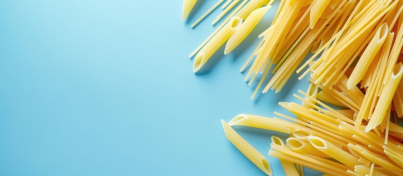 Trofie pasta uncooked on a light blue backdrop top down view with copy space image