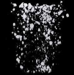 Sea salt crystals in air on black background