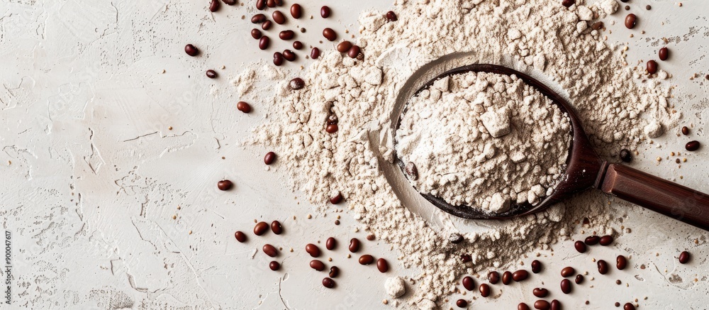 Poster top down view of a spoon resting on kidney bean flour sprinkled with brown seeds providing ample cop