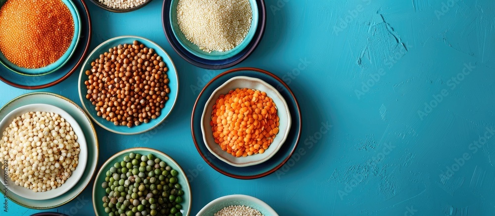 Fototapete various cereals like buckwheat lentils rice and peas presented on plates with a blue background in a
