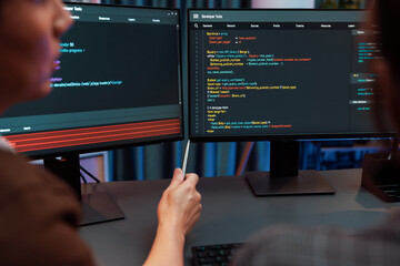 Smart IT developer looking at coding program application on computer screen of online website at...