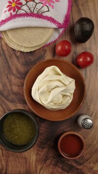 Vertical food video, Putting a bowl with green sauce for meal time in Mexico