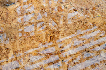 New house construction in residential neighborhood, job site detail, looking down at particle board subfloor with standing water from rain, summer day on job site
