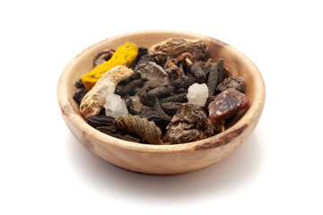 Front view of organic whole spices in a wooden bowl used to make a digestive powder called 