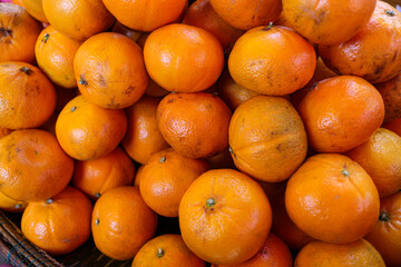 A close-up shot of a pile of fresh, ripe oranges, highlighting their vibrant color and juicy texture. A Heap of Fresh and juicy Oranges background.
