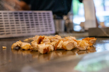 The chef is stirring the delicious Teppanyaki chicken and the aroma is overwhelming