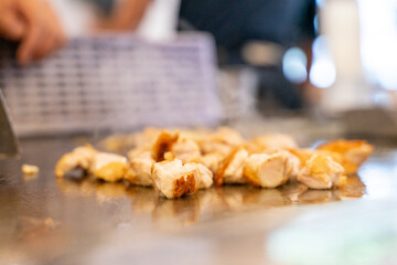 The chef is stirring the delicious Teppanyaki chicken and the aroma is overwhelming