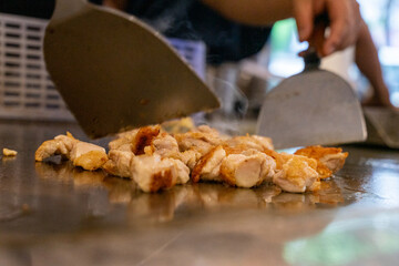 The chef is stirring the delicious Teppanyaki chicken and the aroma is overwhelming