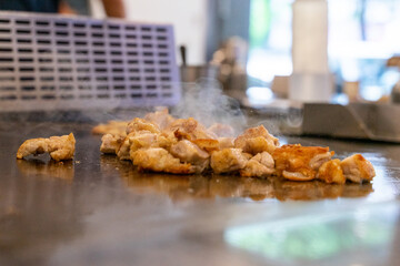 The chef is stirring the delicious Teppanyaki chicken and the aroma is overwhelming