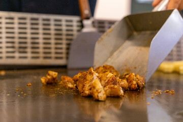 The chef is stirring the delicious Teppanyaki chicken and the aroma is overwhelming