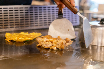 The chef is stirring the delicious Teppanyaki chicken and the aroma is overwhelming