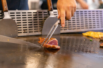 The chef is stirring the delicious Teppanyaki chicken and the aroma is overwhelming