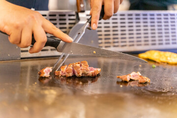 The chef is stirring the delicious Teppanyaki chicken and the aroma is overwhelming