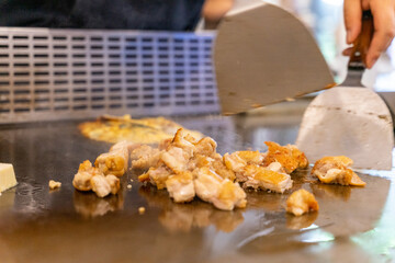 The chef is stirring the delicious Teppanyaki chicken and the aroma is overwhelming