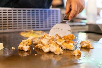 The chef is stirring the delicious Teppanyaki chicken and the aroma is overwhelming